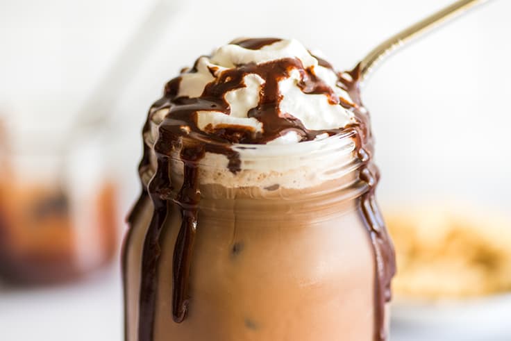 Photo of iced mocha with whipped cream and chocolate drizzle.
