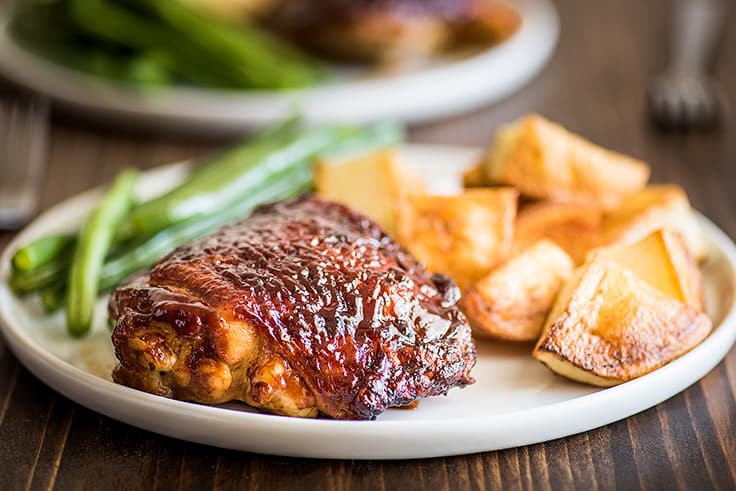 Baked bbq chicken thigh on a plate.