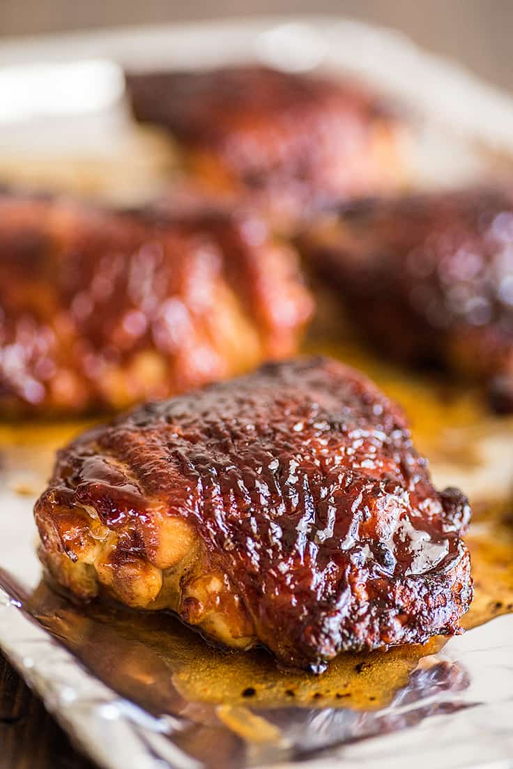 BBQ chicken thighs on a baking sheet.