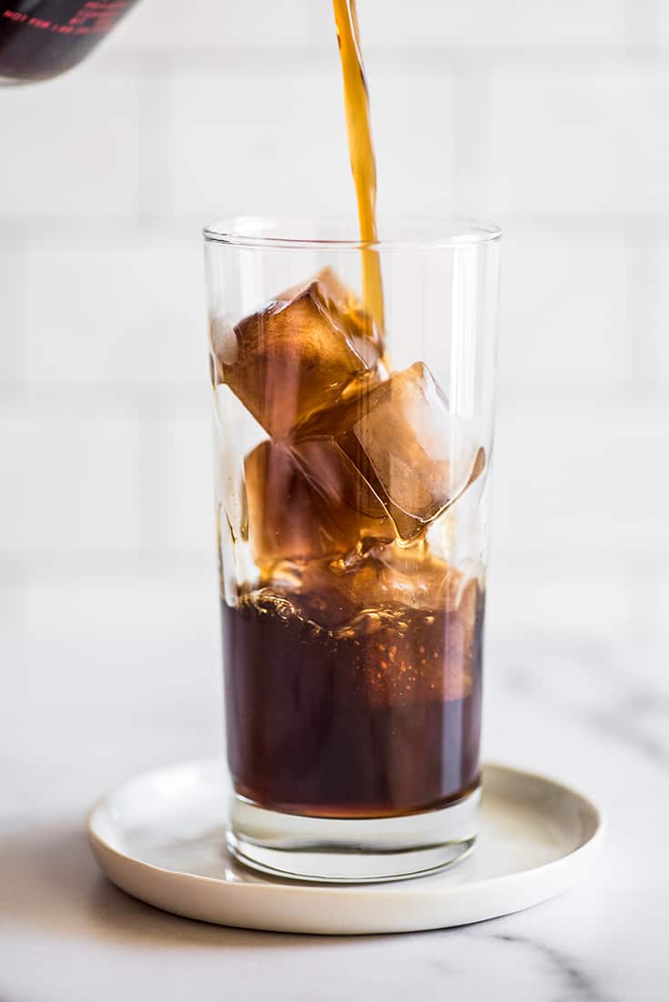 Coffee being poured over coffee ice cubes.