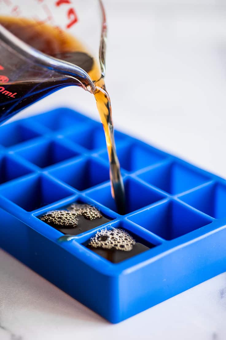 Coffee being poured into mold to make coffee ice cubes.