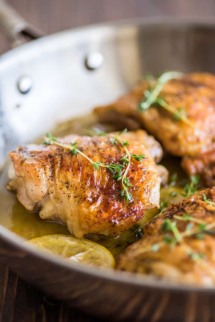 Lemon chicken thighs in skillet.