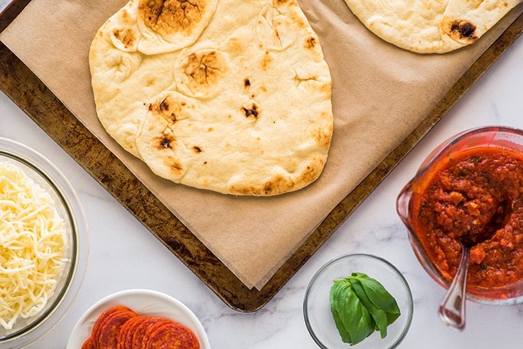 Overhead photo of naan pizza being assembled.