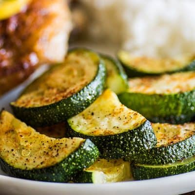 Roasted zucchini on a plate with chicken.