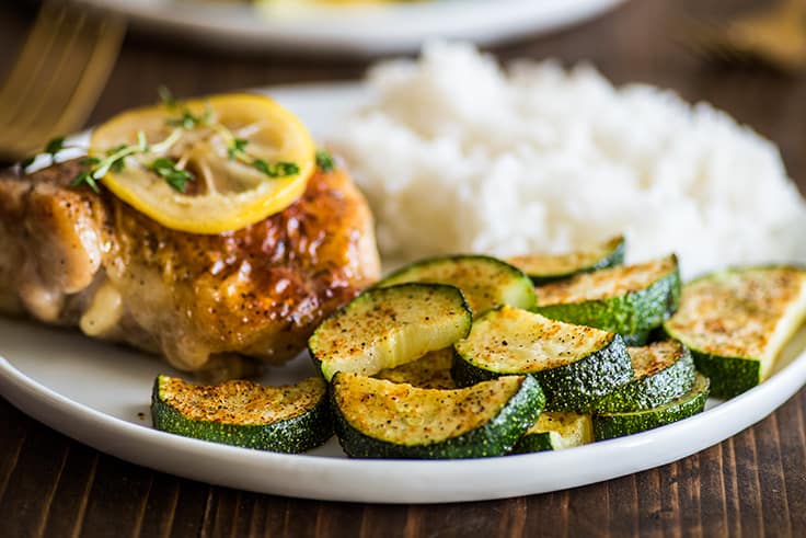 Roasted zucchini on a plate with chicken.