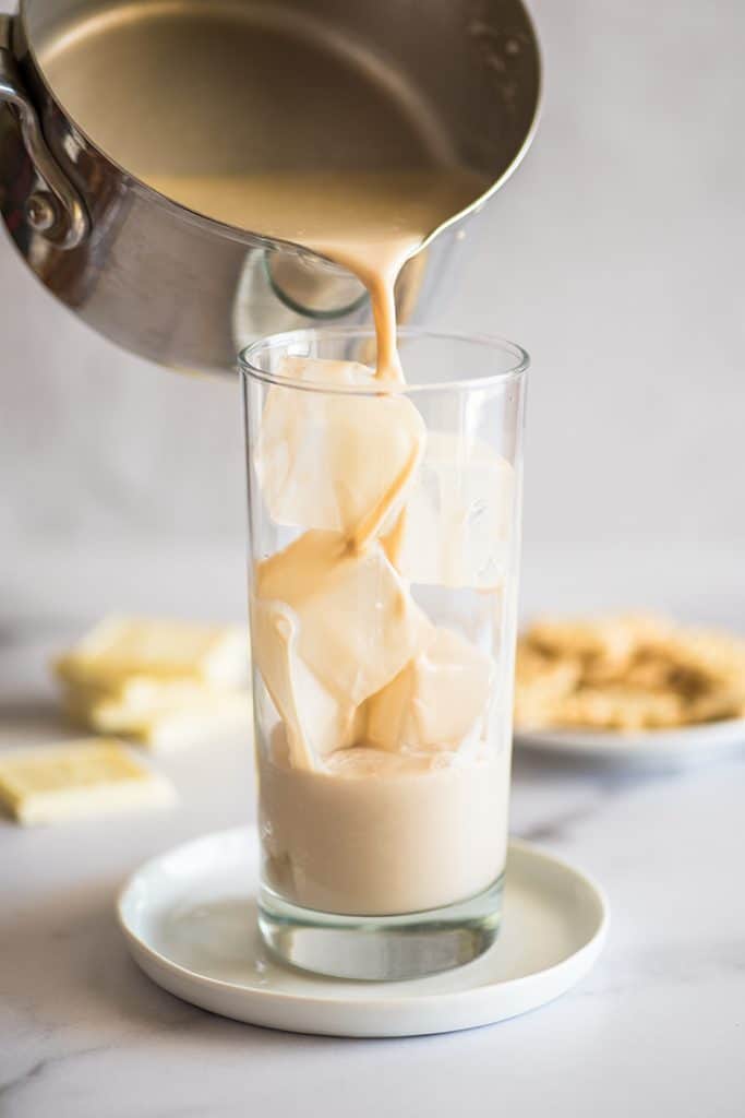 Iced white chocolate mocha being poured into a glass.