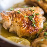 Lemon chicken thighs in skillet.