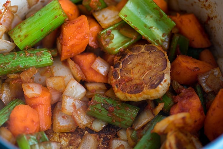 Photo of vegetables and tomato paste cooking for braised short ribs.