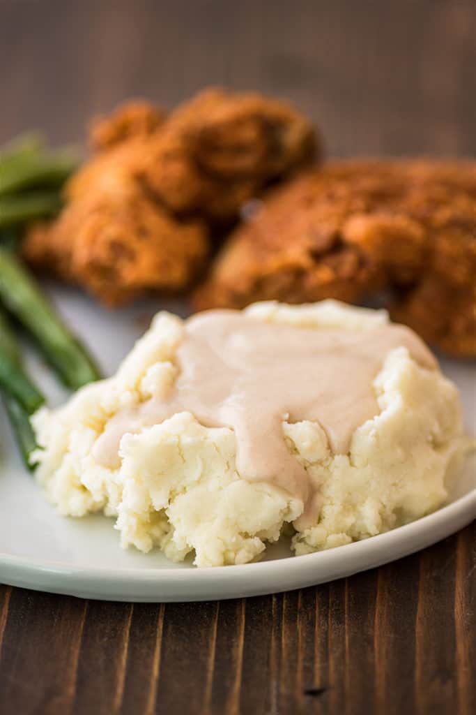 Easy gravy over mashed potatoes on a plate.