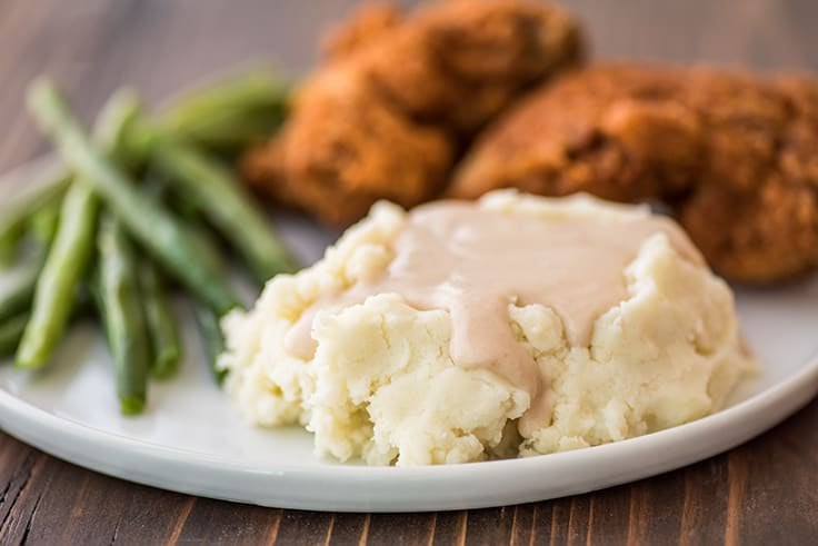 Easy gravy over mashed potatoes on a plate with chicken