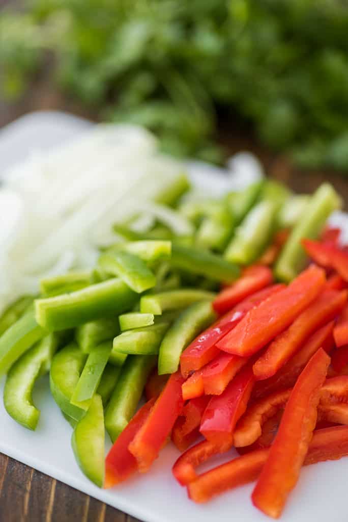 Onion and green and red bell peppers cut for fajitas.