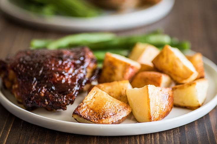 Roasted red potatoes on a white plate.