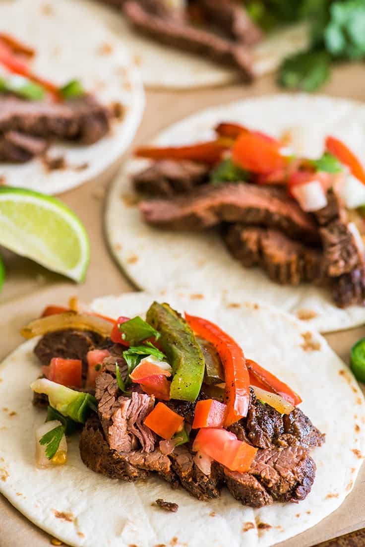 Picture of steak fajitas with carne asada and bell peppers on tortillas.