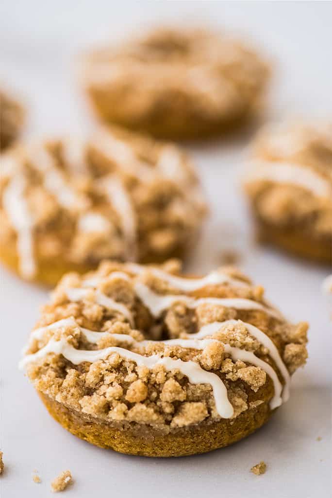 Pumpkin donuts with streusel and glaze drizzle.