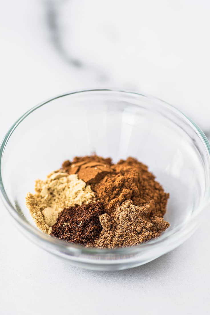 Spices for pumpkin pie spice in a bowl.