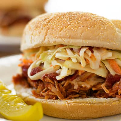 Slow cooker BBQ chicken sandwiches on white plates.
