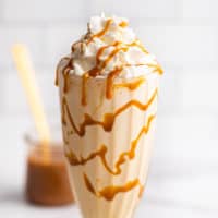 Caramel milkshake in a glass cup with whipped cream.