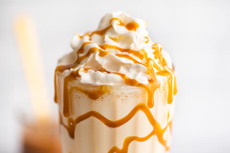 Close photo of caramel milkshake with caramel drizzle.