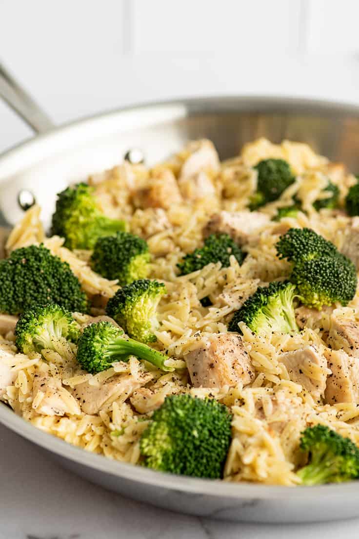 Chicken and broccoli orzo in a skillet.