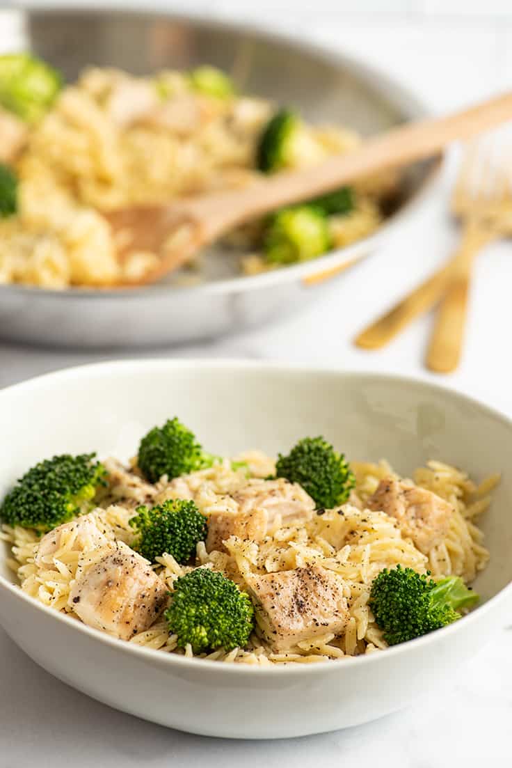 Chicken and broccoli orzo in a white bowl.