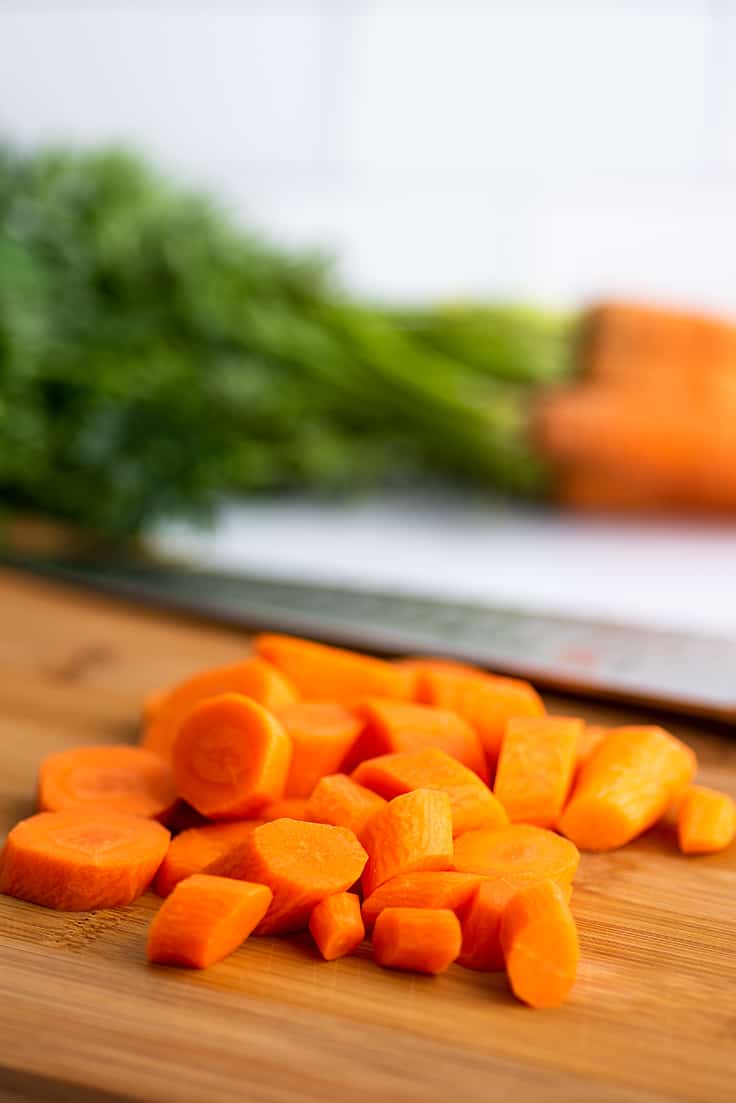 Chopped carrots on a cutting board ready to be microwaved.