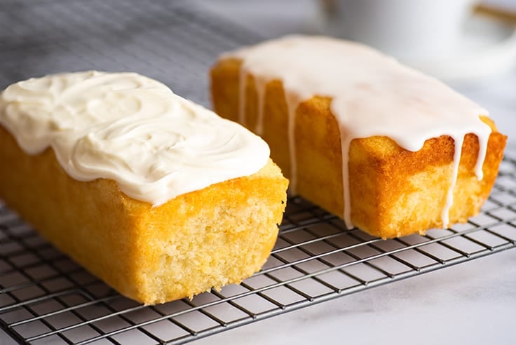 Lemon pound cake with cream cheese glaze on a cooling rack.