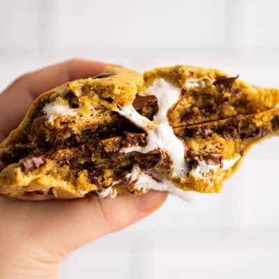 Hand holding a s'mores cookie folded in half.