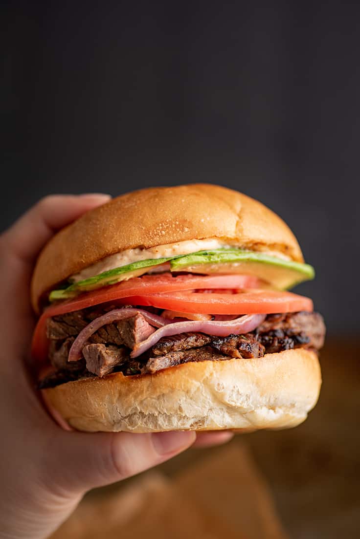 Hand holding a Carne Asada Sandwich