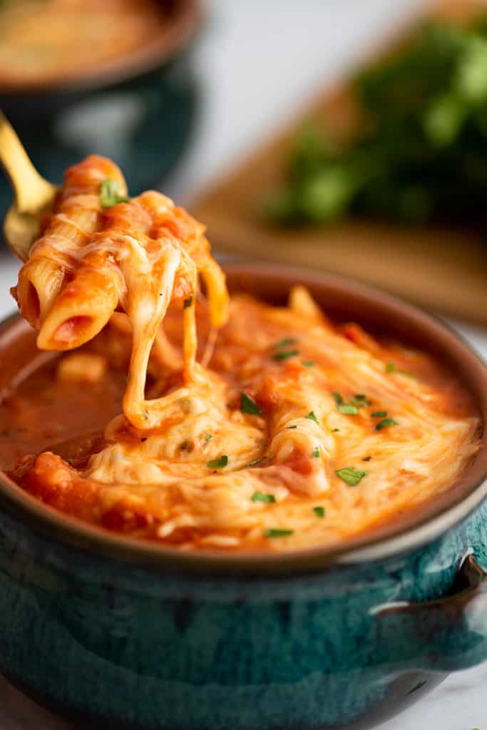 Spoonful of chicken parm soup with melted cheese.