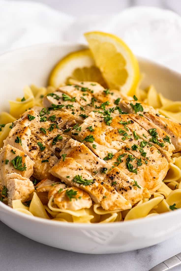 Chicken in white wine lemon butter sauce sliced over egg noodles.