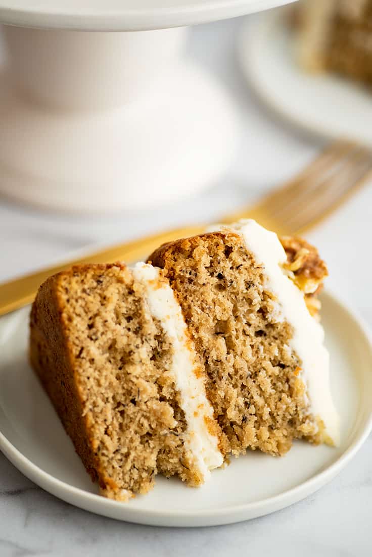 Slice of small two layer banana cake on a plate.