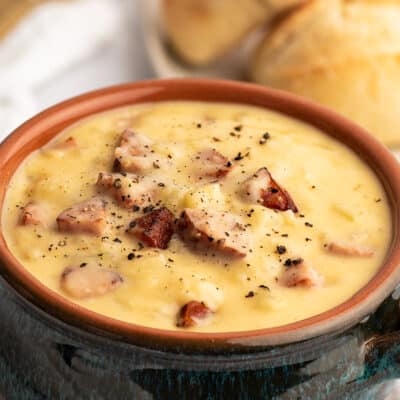 Blue bowl filled with cheesy sausage potato soup.
