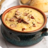 Blue bowl filled with cheesy sausage potato soup.