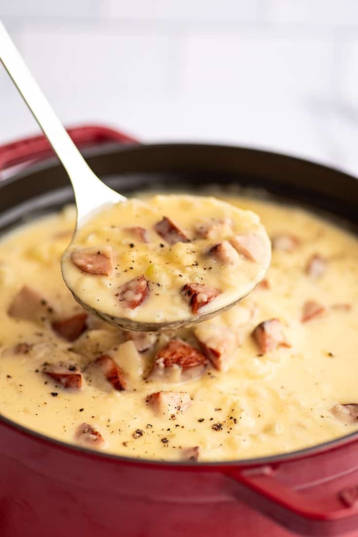 Ladle full of sausage and potato soup.