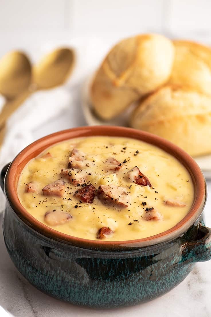 Blue bowl filled with cheesy sausage potato soup.