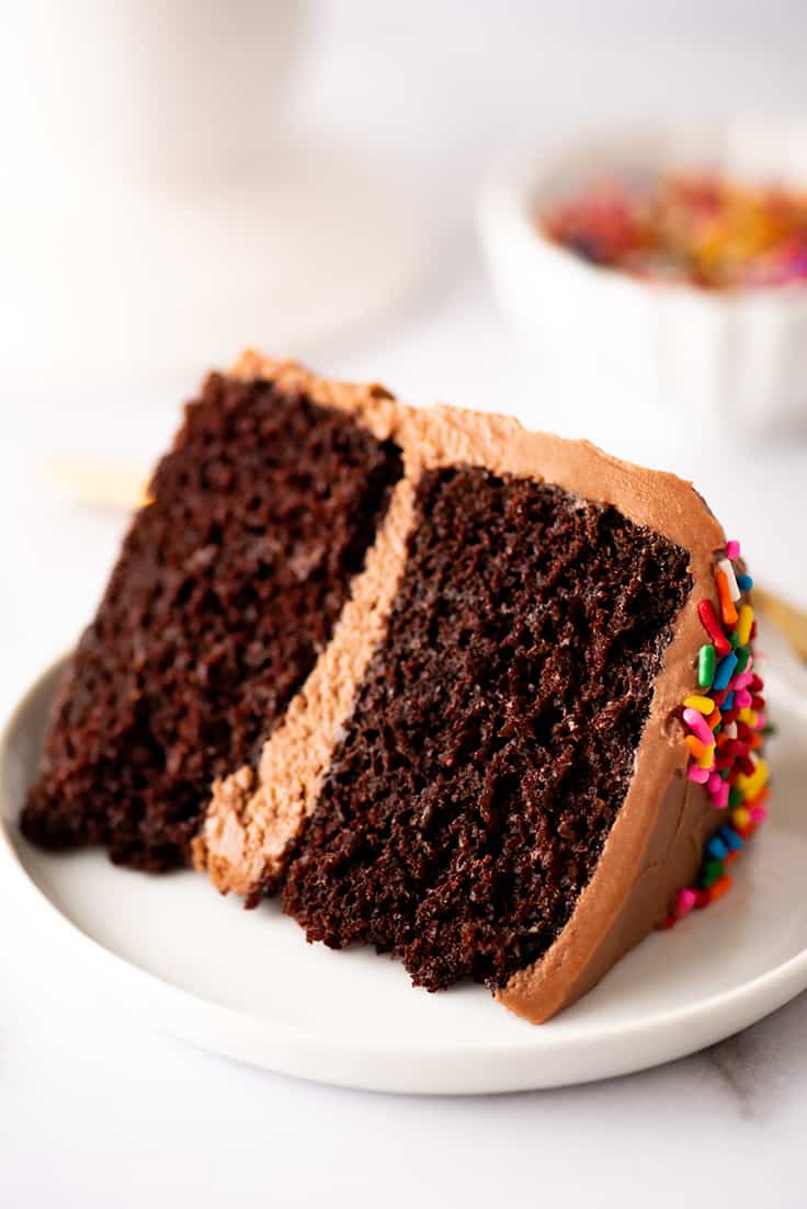 Slice of a small chocolate layer cake on a plate.
