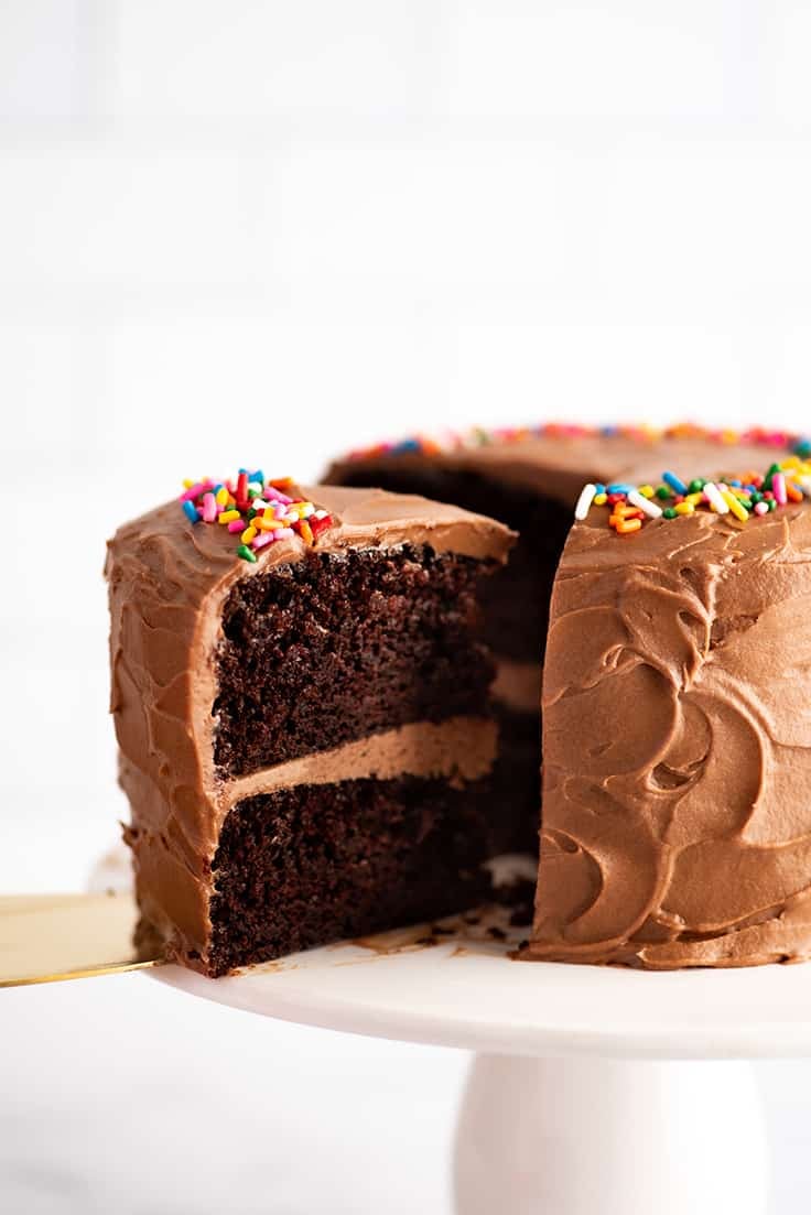 Small chocolate cake being cut into slices.
