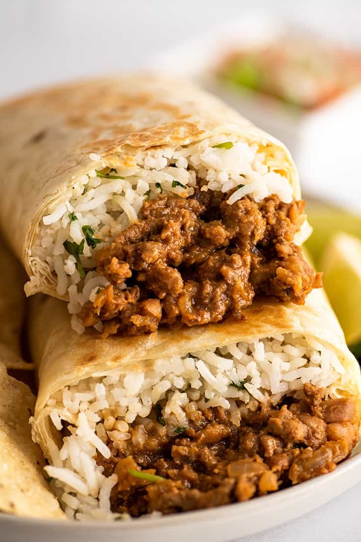 Close up photo of freezer burritos stacked on a plate.