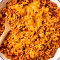 American goulash with cheese in a white Dutch oven.