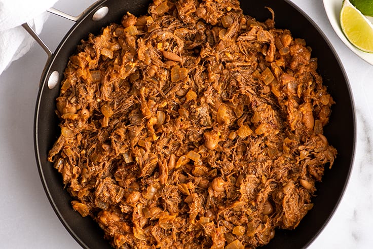 Shredded beef burrito filling in a pan.