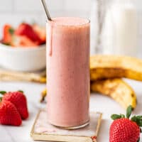 Strawberry banana milkshake in a tall glass.