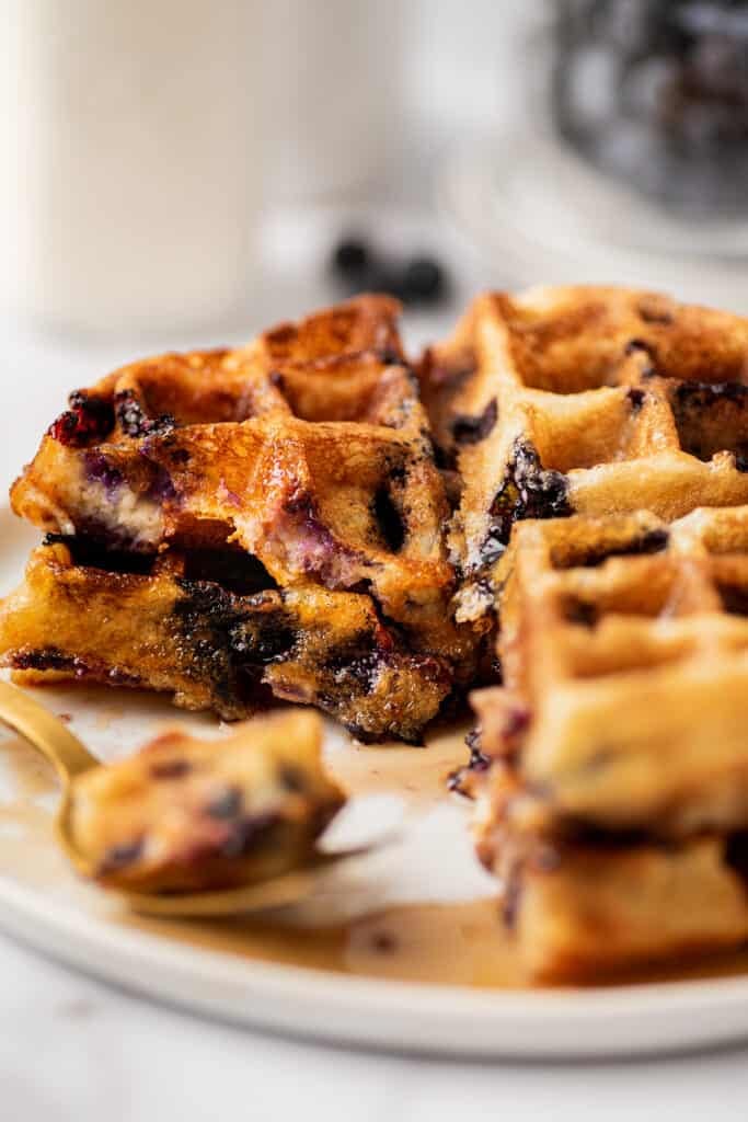 Blueberry waffle pieces on a white plate.