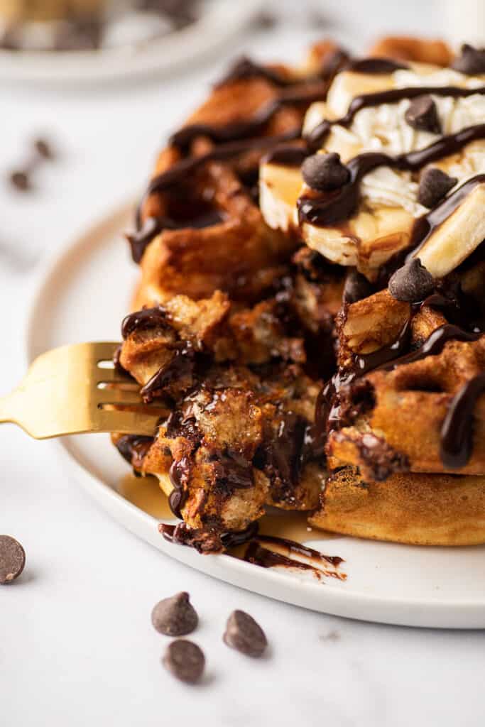 Close photo of a fork full of chocolate chip waffles.