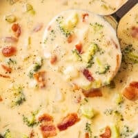 A ladle scooping out cheesy broccoli potato soup.