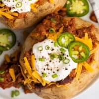 Chili baked potatoes on a white plate.