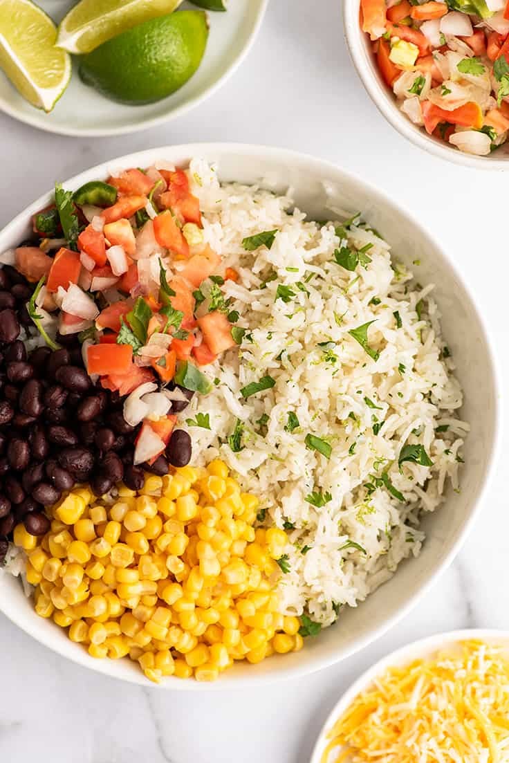 Cilantro lime rice in a bowl with burrito toppings.