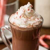 Peppermint hot chocolate with whipped cream in a glass mug.