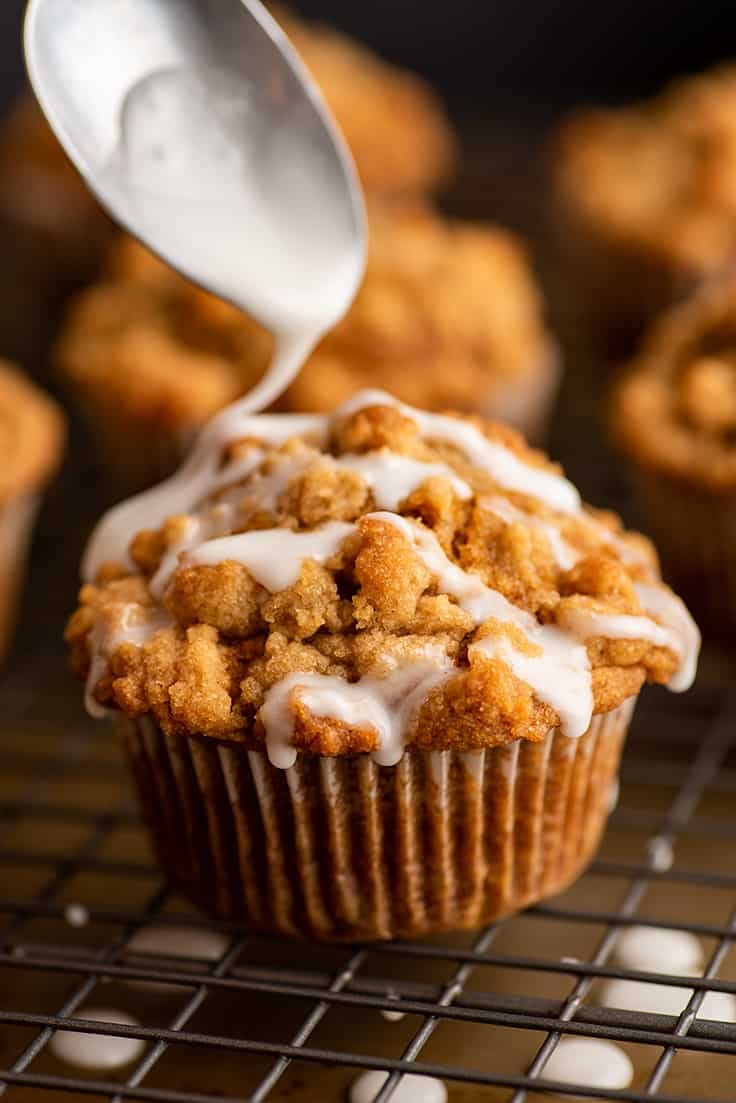 Pumpkin muffin being drizzled with glaze.
