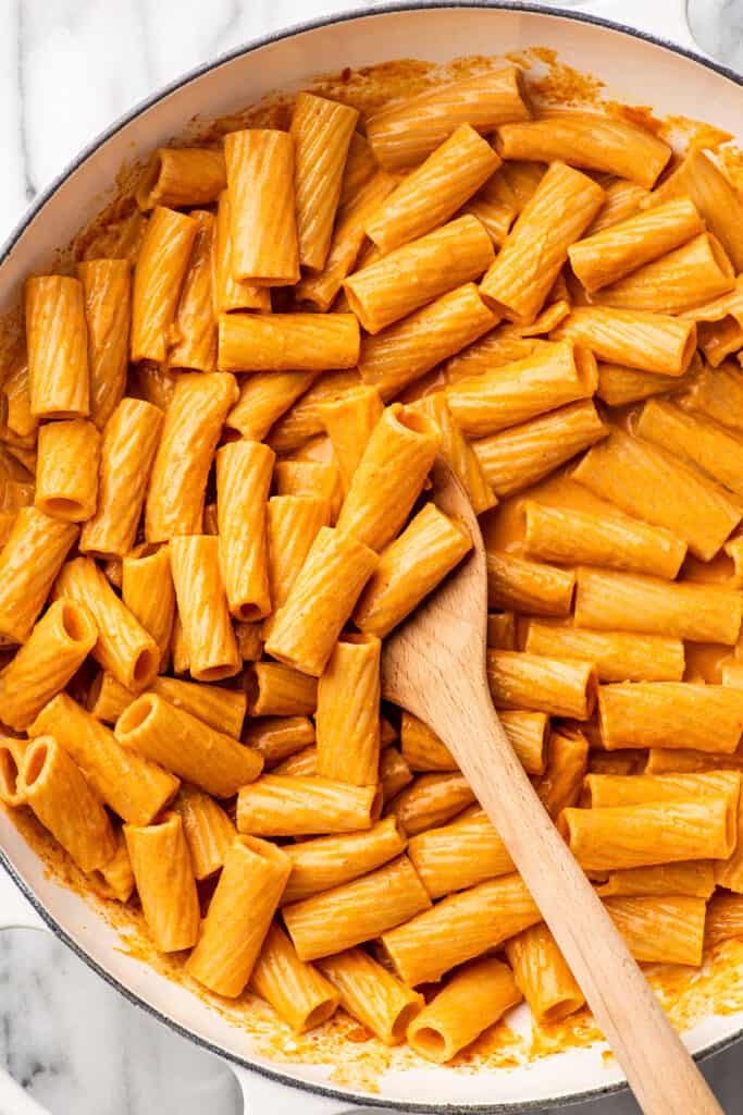 Spoon scooping pasta in vodka sauce.