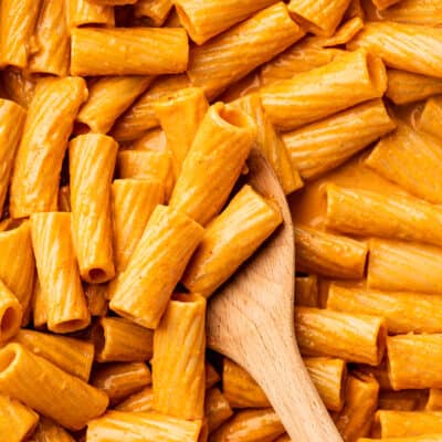 Spoon scooping pasta in vodka sauce.